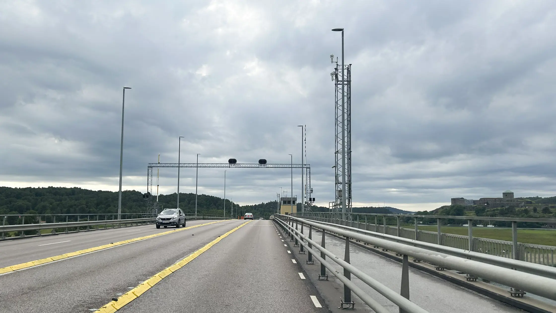 Två personbilar, en i varje riktning, syns köra över Jordfallsbron.