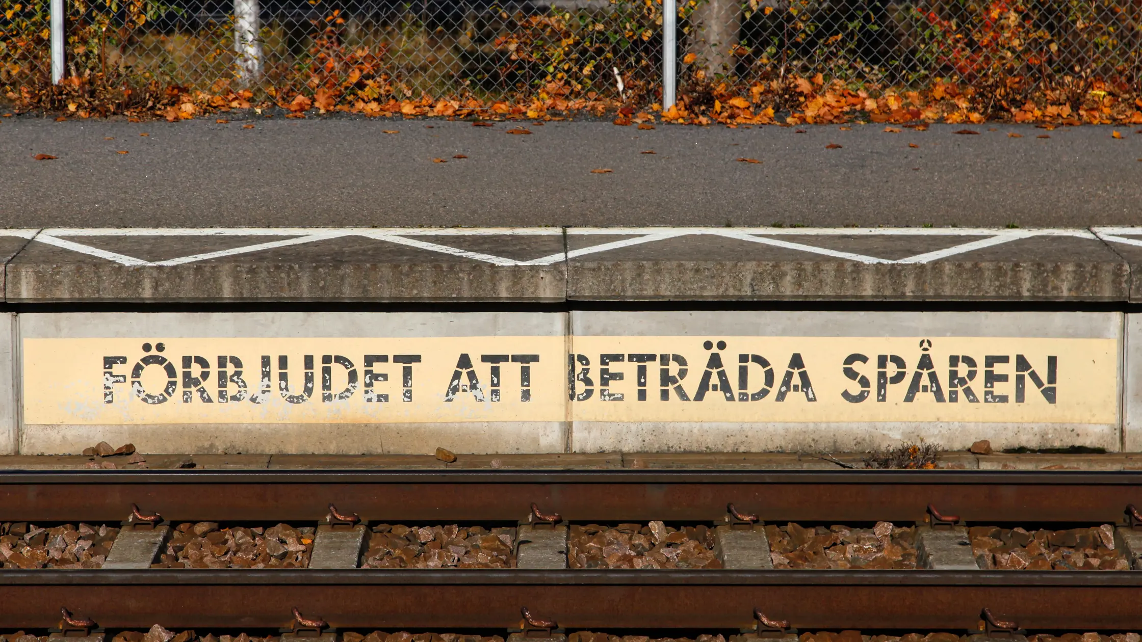 Närbild på järnvägsspår med skylten "Förbjudet att beträda spåren"